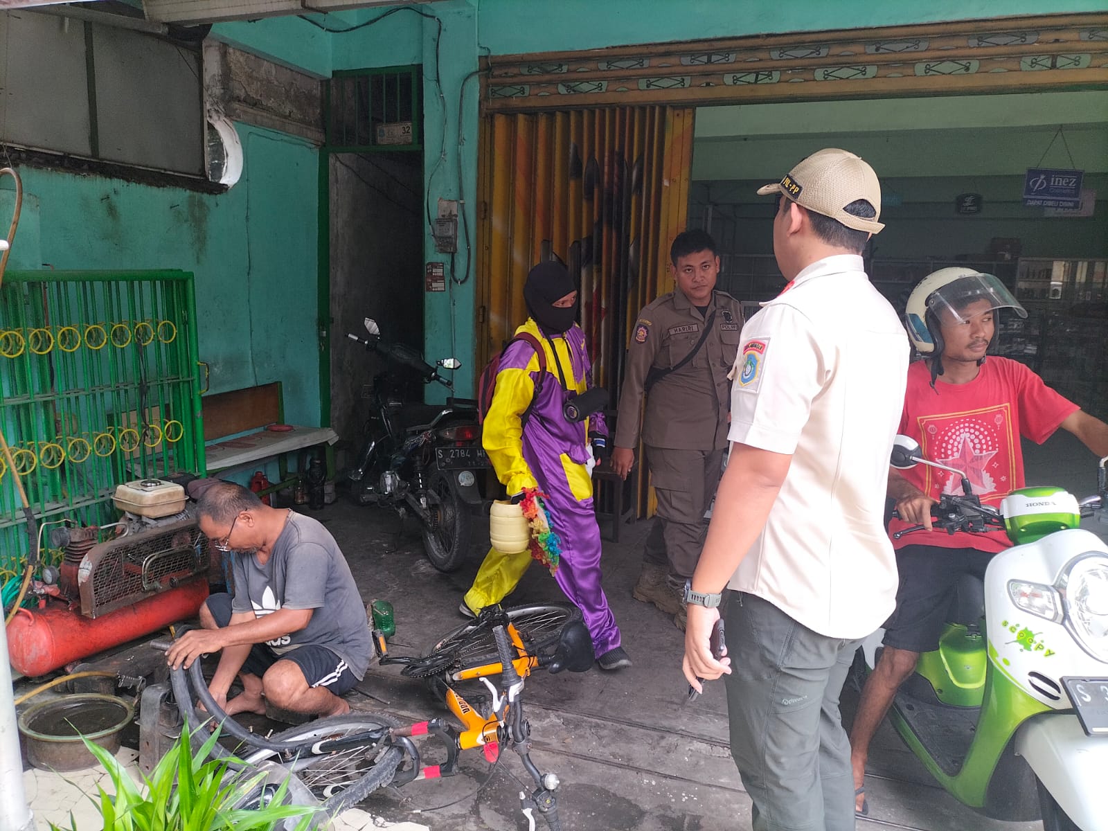 DIRAZIA: Seorang berpakaian ala badut yang biasa mangkal di traffic light didatangi petugas Satpol PP. (GAMAL A/RDR.LMG)