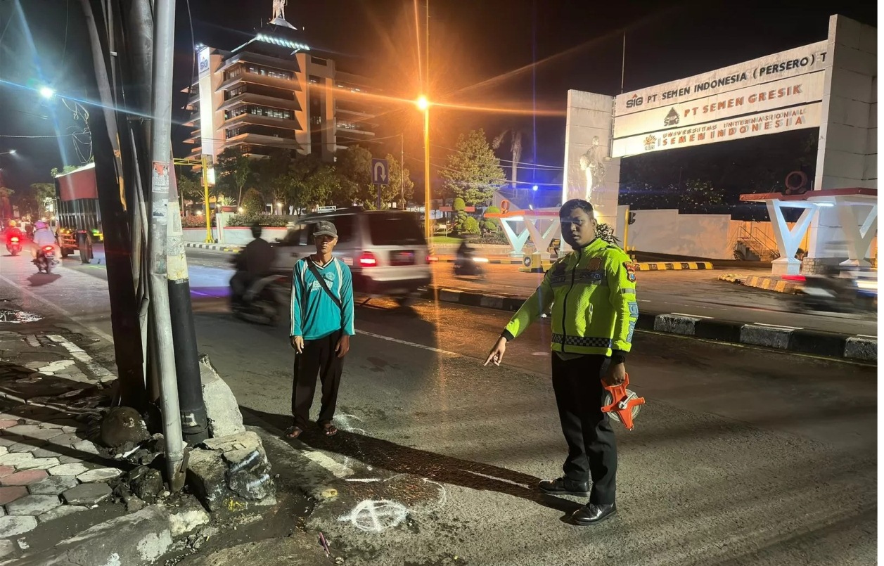 TEMPAT KEJADIAN PERKARA: Anggota Unit Laka Satlantas Polres Gresik melakukan olah TKP kecelakaan di Jalan Raya Veteran Kelurahan Singosari, Kecamatan kebomas, Kabupaten Gresik. (Yudhi Radar Gresik)