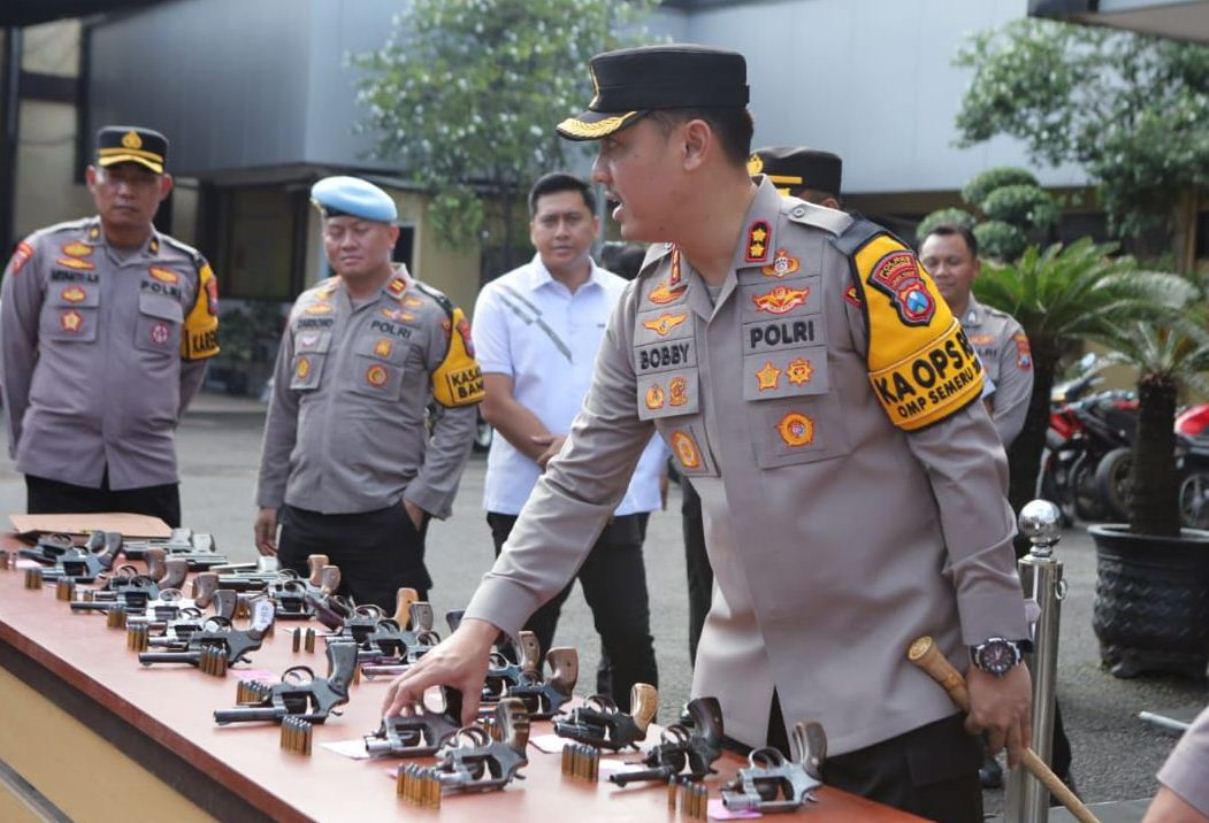 CEK SENPI: Kapolres Lamongan AKBP Bobby A Condroputra memeriksa kondisi senjata api yang dibawa anggotanya. (IST/RDR.LMG)