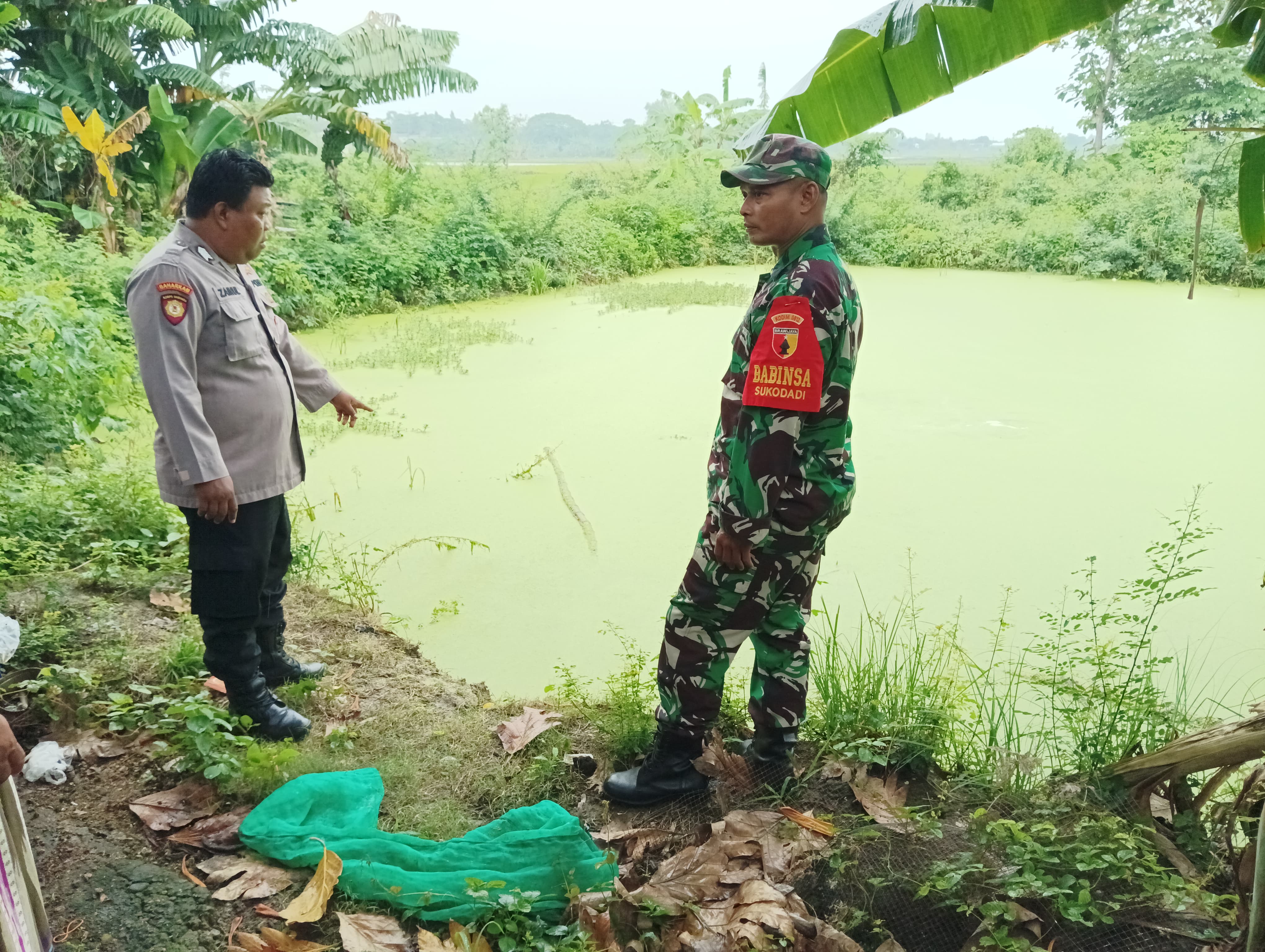 Petugas mendatangi TKP balita tercebur di Empang (Ist. / Radar Lamongan)