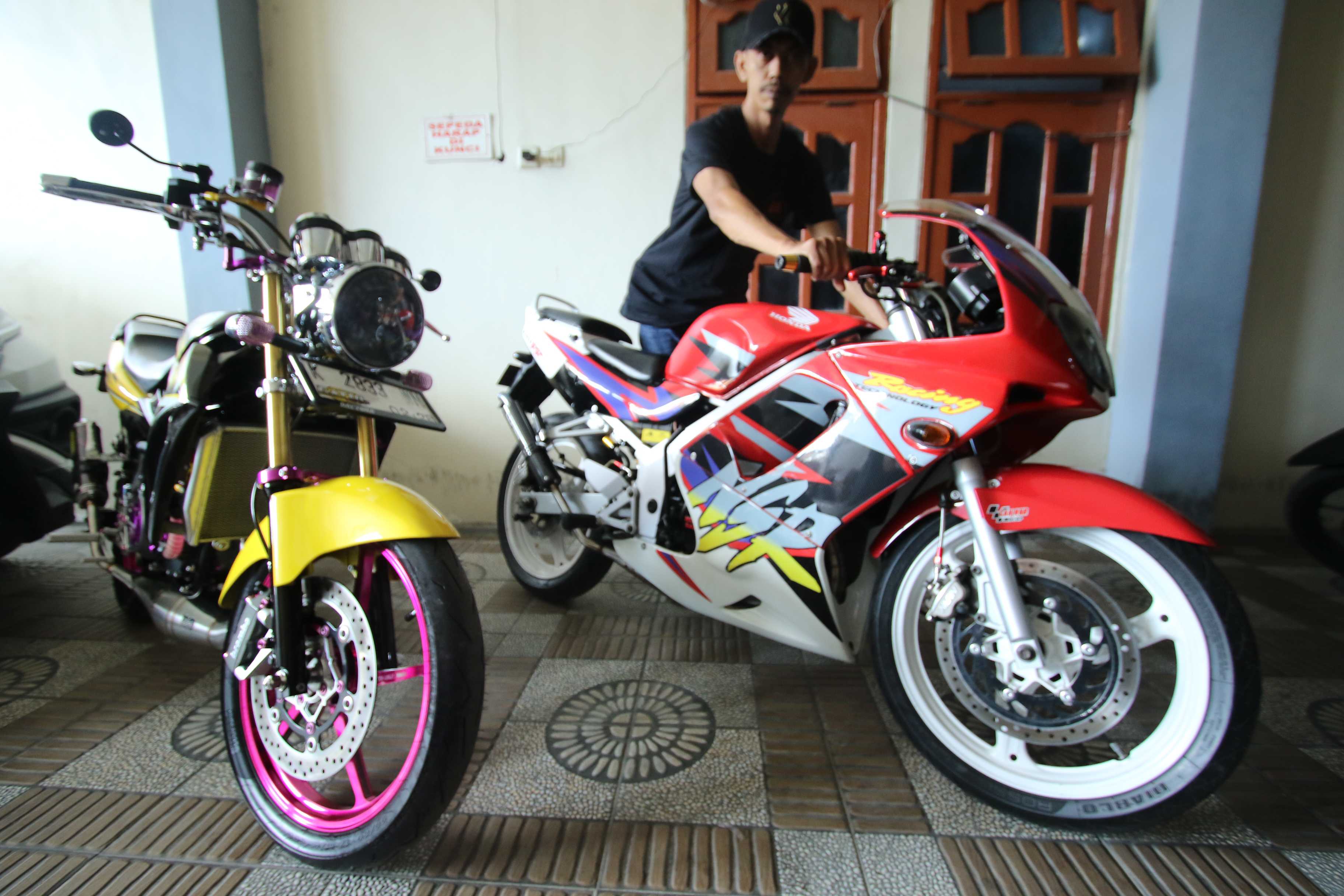 SEPERTI BARU: Abdul Karim menunjukkan dua motor sport klasik miliknya yang telah dimodifikasi dan direstorasi. (Anjar / Radar Lamongan)