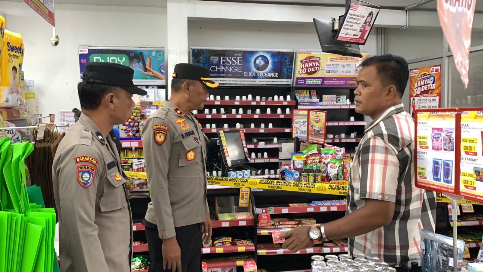 Petugas Polsek Lamongan Kota saat mengecek minimarket yang disatroni pencuri di Desa Plosowahyu.