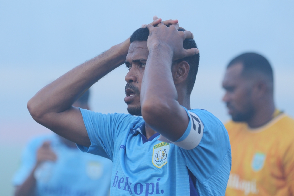 Kapten Persela, Hasyim Kipuw, memegang kepala usai Persela dipastikan gagal lolos babak playoff perebutan juara 3