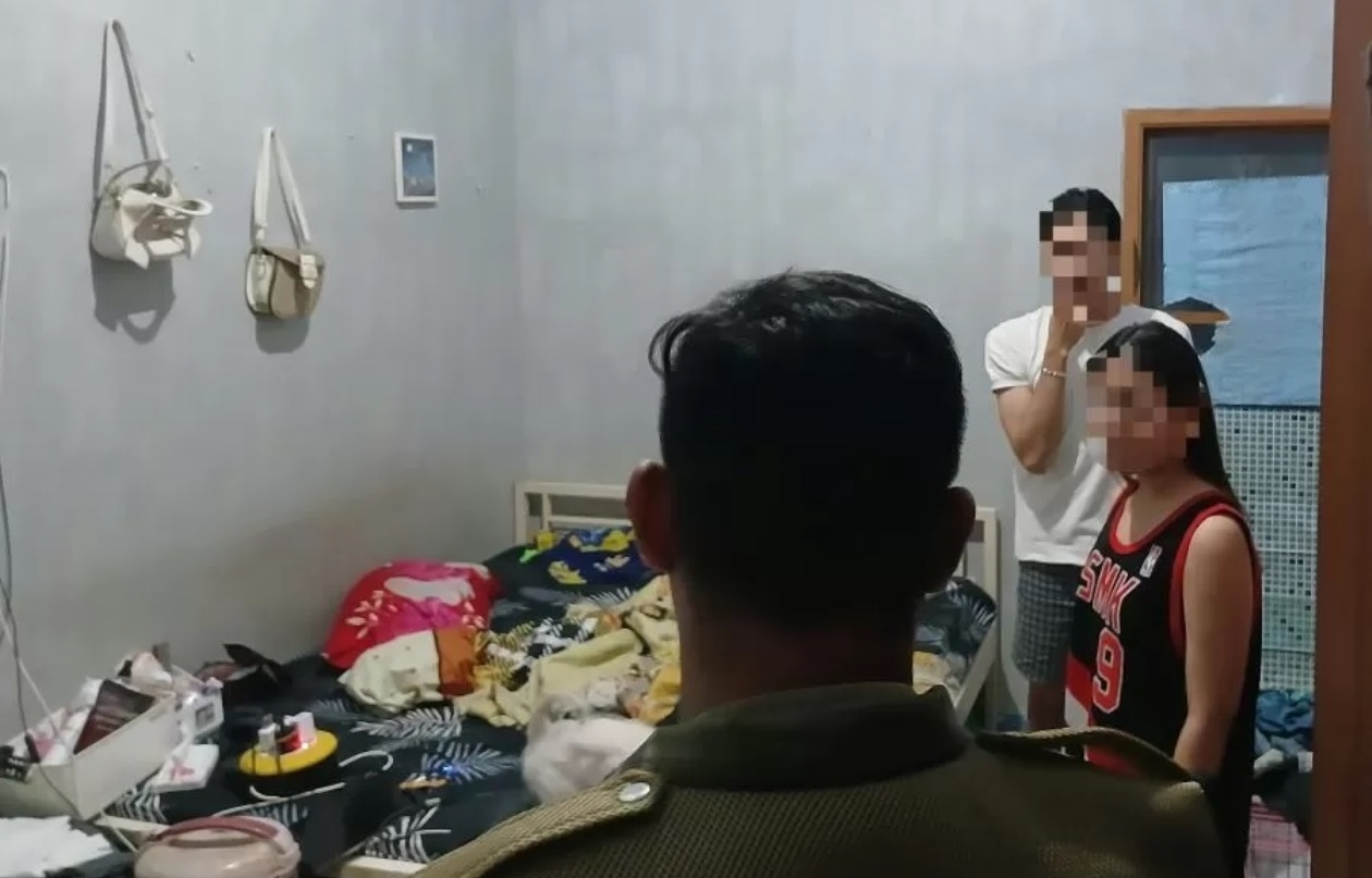 SEMPAT BERKELIT: Petugas Satpol PP Kota Mojokerto mendapati sepasang kekasih tinggal sekamar saat razia, Sabtu (22/2) malam. (adi/jprm)