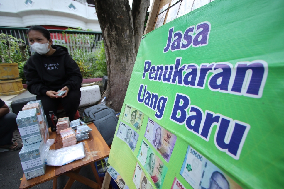 MENGAIS REJEKI: Salah satu jasa penukaran uang baru di pinggir jalan protokol Lamongan.