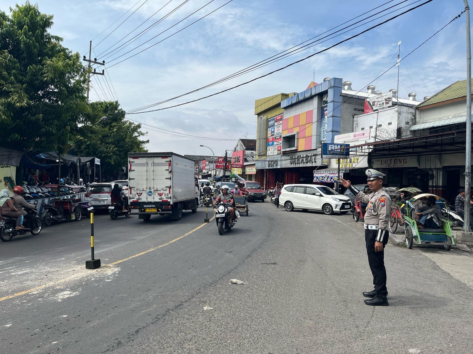 ATUR LALIN: Petugas memasang pembatas di jalan nasional, tepatnya di depan Pasar Babat.