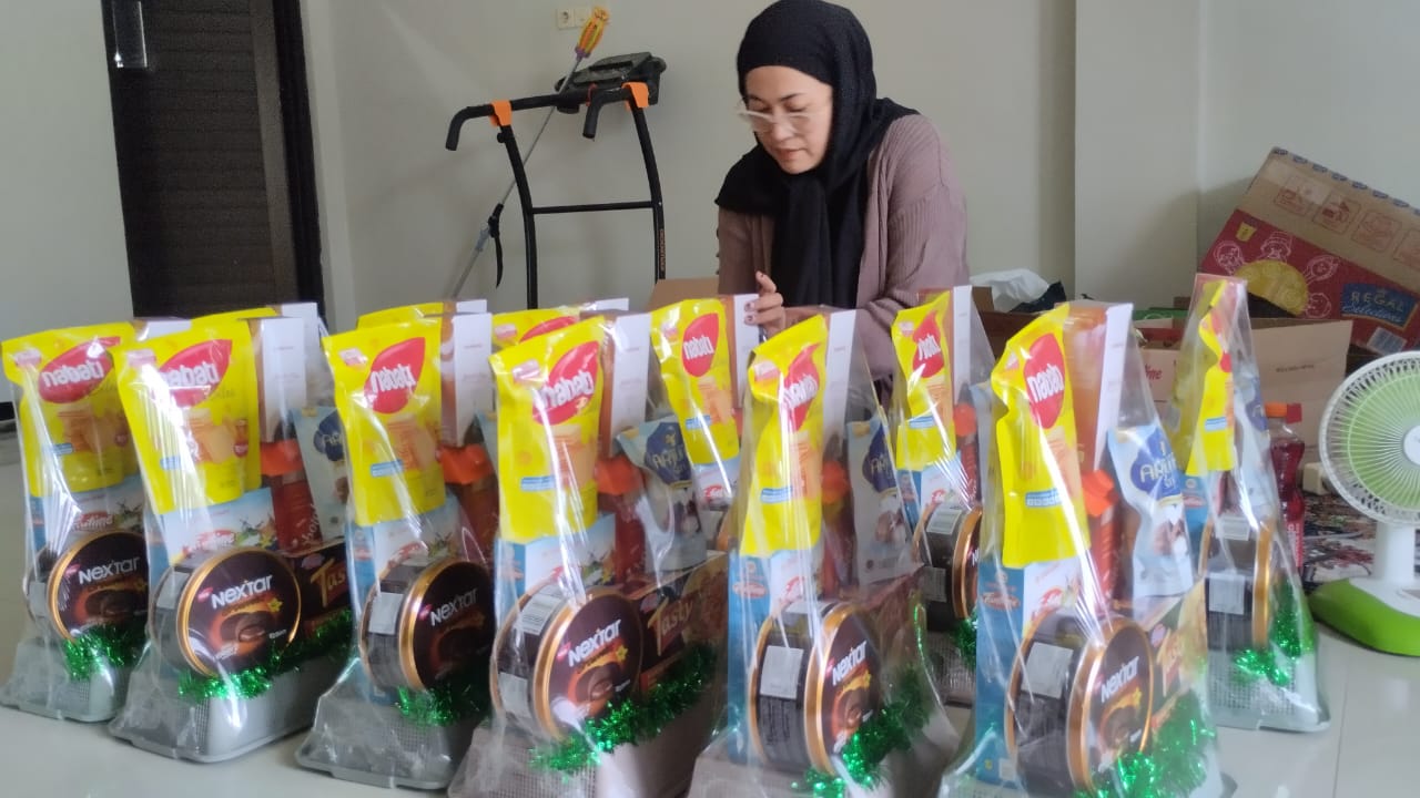 BANYAK PESANAN: Yuli dengan cekatan membungkus parsel pesanan konsumennya.