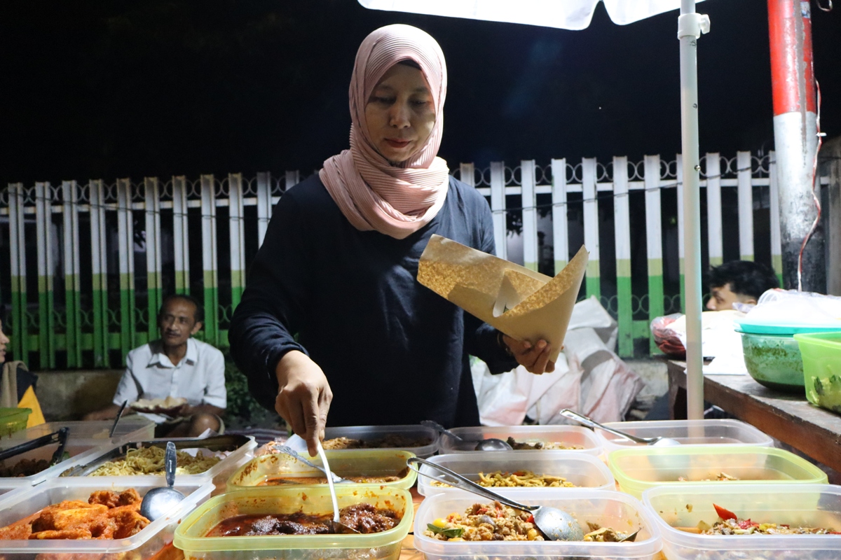 BUKA LAPAK DI RAMADAN: Istiqomah saat menjual menu sahur. Di hari - hari biasa, dia berjualan nasi dengan pembungkus daun pisang. (RIKA RATMAWATI/RDR.LMG)