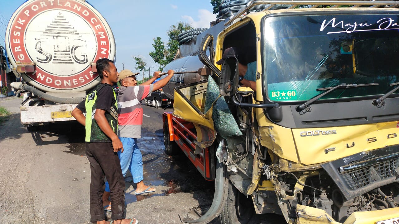 Kondisi truk tangki air usai menabrak truk muatan semen curah di jalan nasional.
