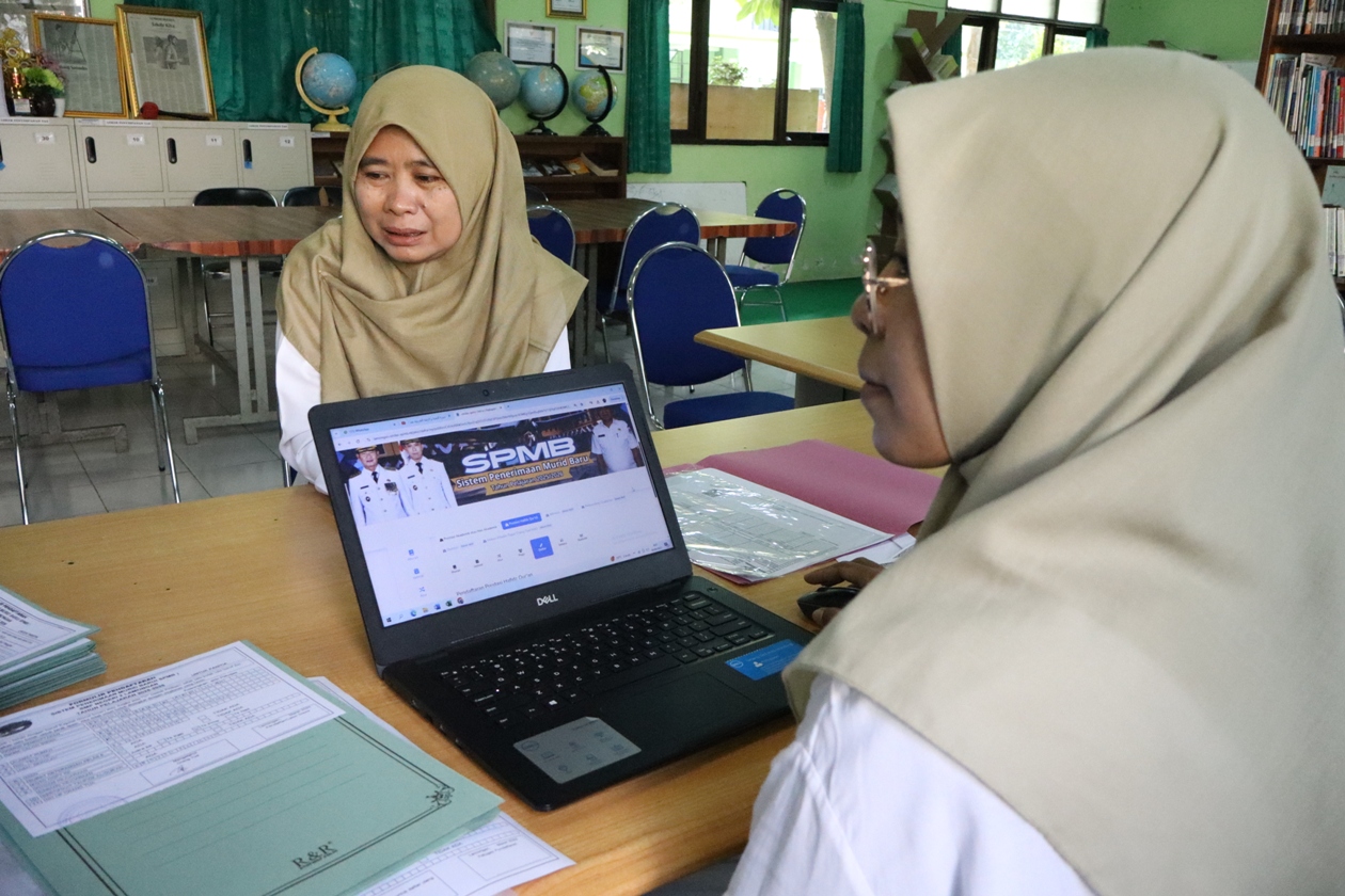 ONLINE: Panitia sistem penerimaan murid baru di SMP Negeri 2 Lamongan menggunakan laptop untuk mengecek pendataan. (ASIF ALAFI/RDR.LMG)