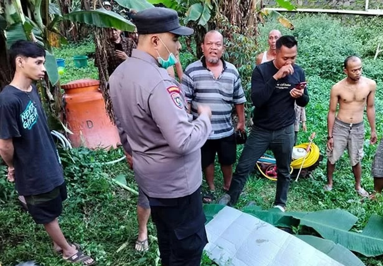BARU SEHARI KERJA: Jenazah Sumarno ditutup daun pisang saat ditemukan di kebun durian Purwodadi, Pasuruan. (Radar Bromo)