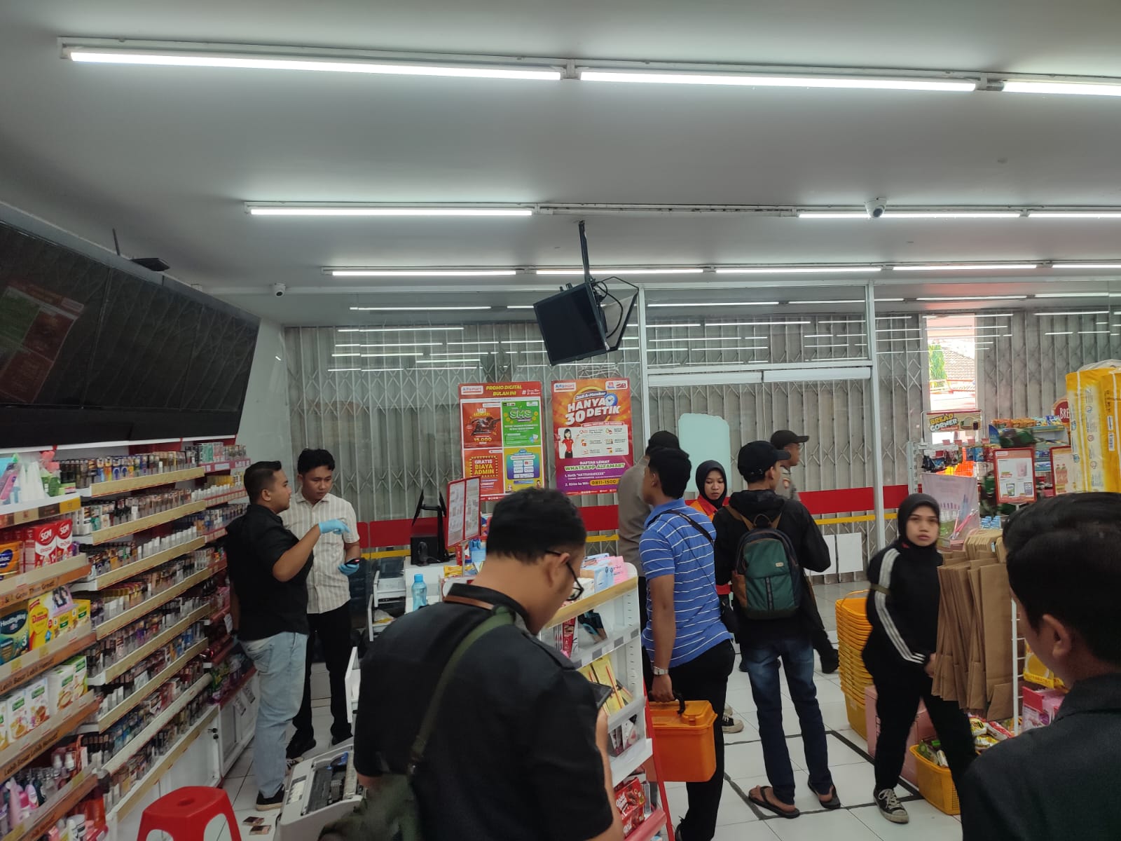OLAH TKP: Petugas Polres Lamongan mencari petunjuk di minimarket yang ada di Desa Ardirejo, Kecamatan Sambeng, yang kebobolan. (IST/RDR.LMG)