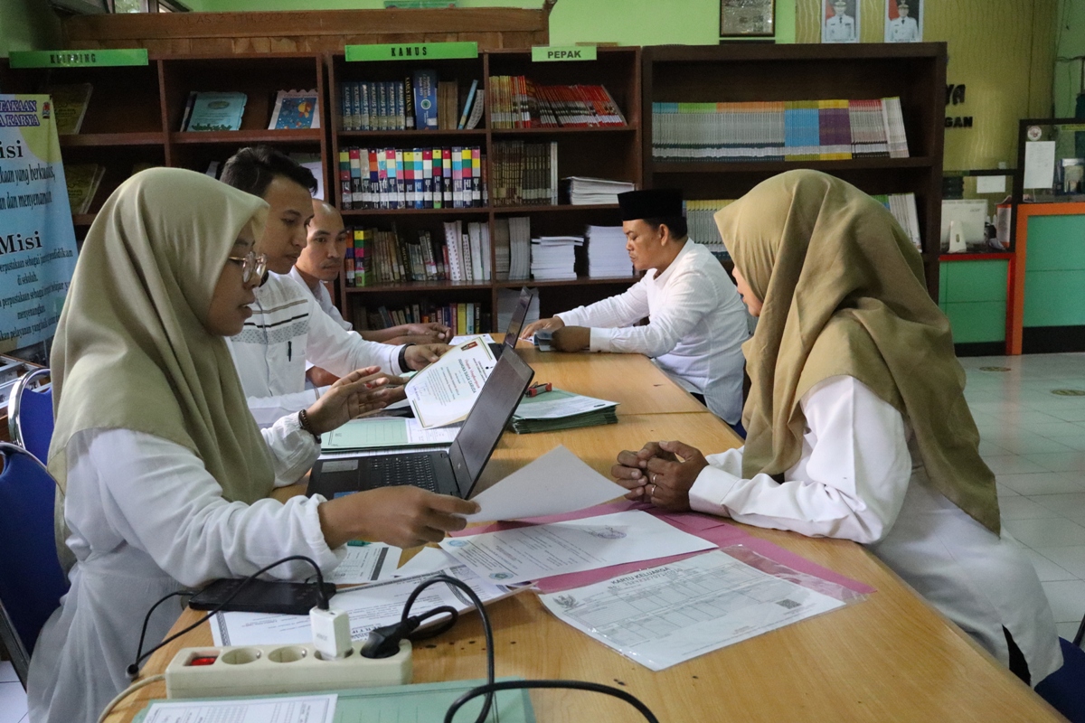 SIBUK: Petugas SPMB di SMPN 2 Lamongan mengecek administrasi untuk jalur prestasi. SPMB jalur prestasi ditutup hari ini. (ASIP ALAFI/RDR.LMG)