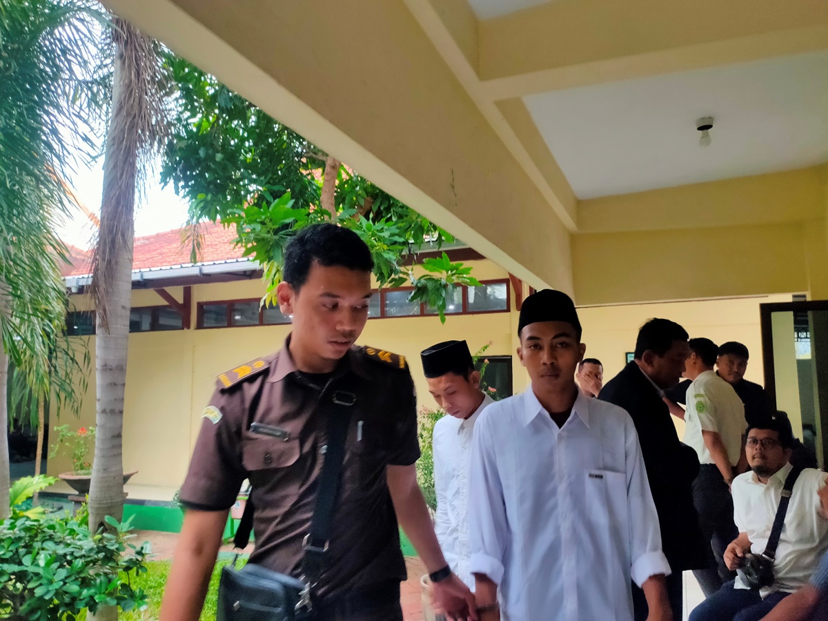 GARA - GARA PUKUL PACAR: Setiyan Hadi Wibowo dikawal petugas di PN Lamongan. (IST/RDR.LMG)