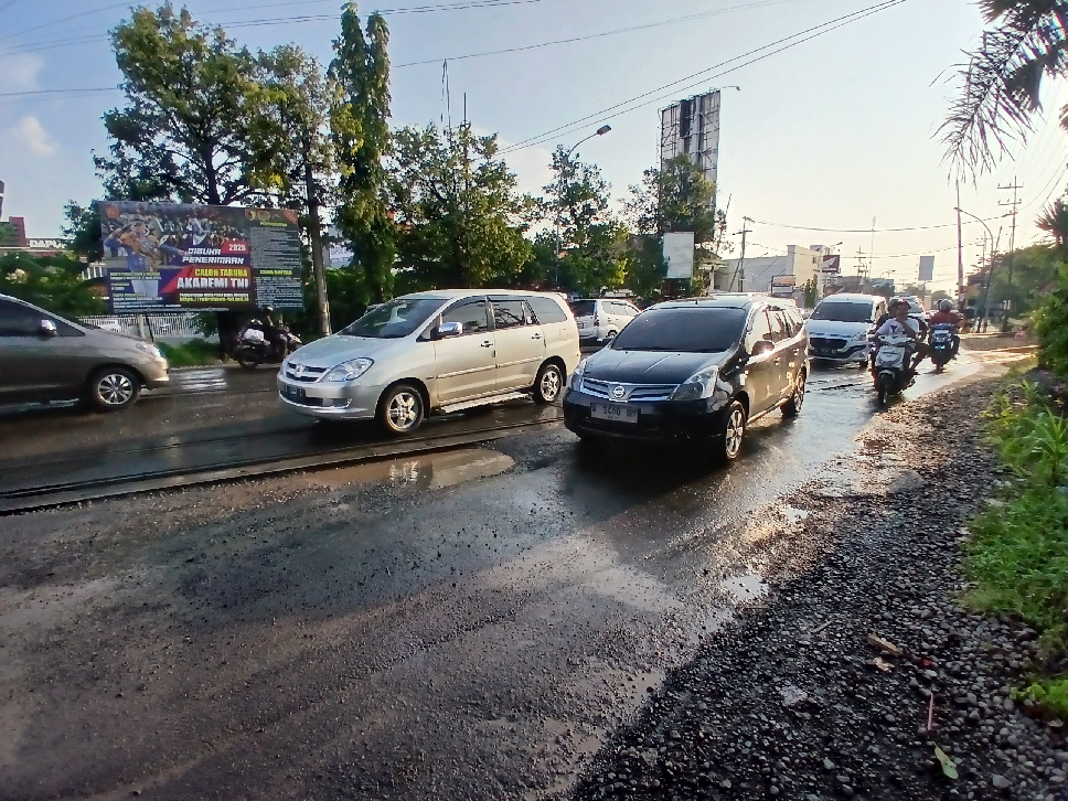Lubang digenangi air tampak di perlintasan KA di Jalan Panglima Sudirman.
