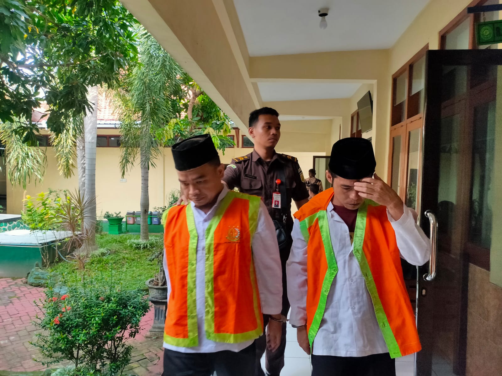 BERKAS BERBEDA: Terdakwa penipuan senilai Rp 500 juta, Afrian dan Dondri saat menuju ruang sidang.