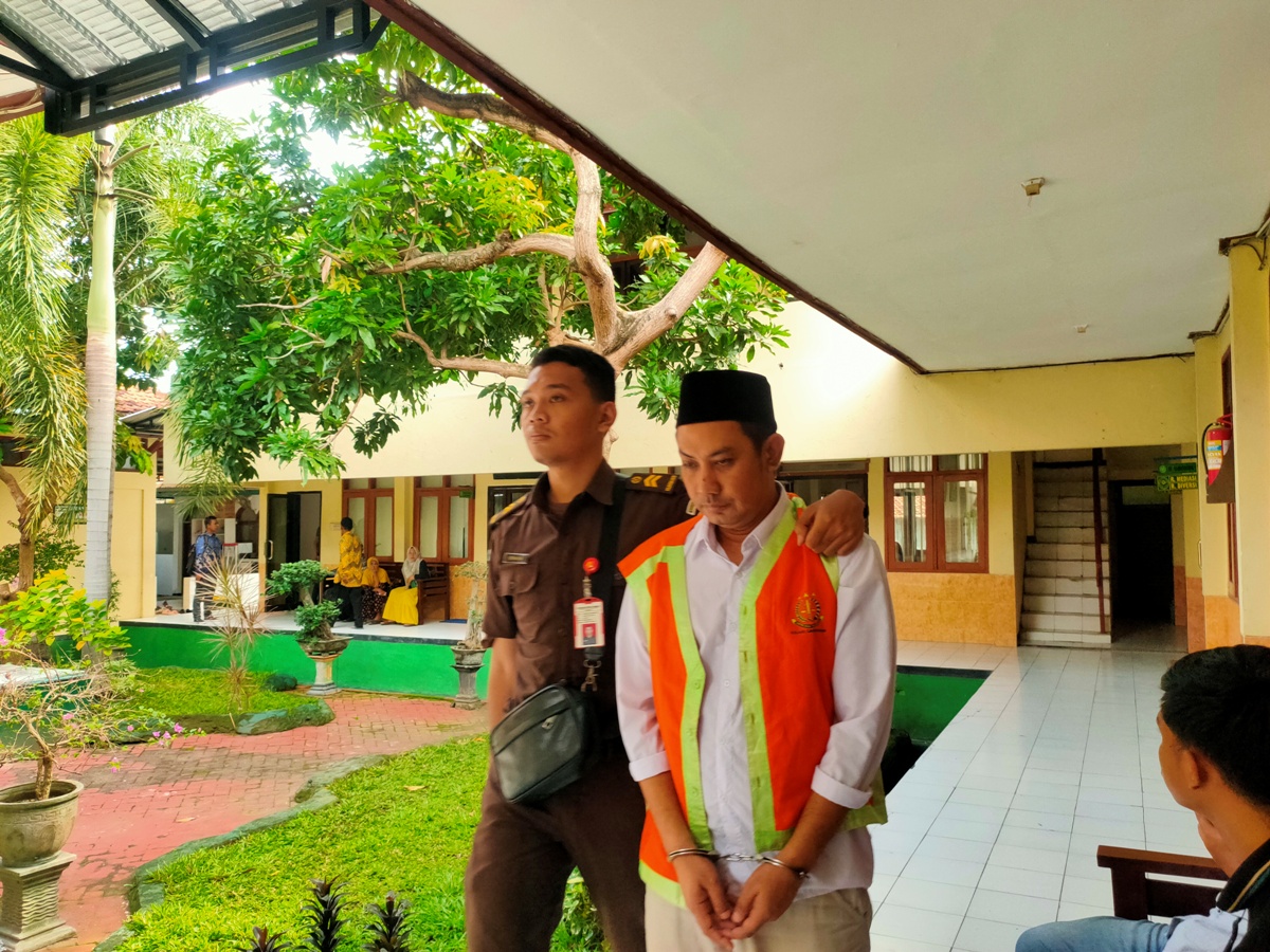 DIKAWAL PETUGAS: Zainal Fatoni di Pengadilan Negeri Lamongan. Dia menjadi terdakwa kasus SS. (IST/RDR.LMG)