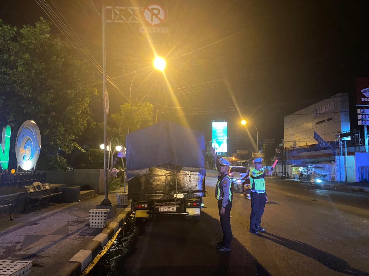 BERI EFEK JERA: Petugas memberikan surat tilang kepada sopir truk yang parkir di bahu jalan nasional.