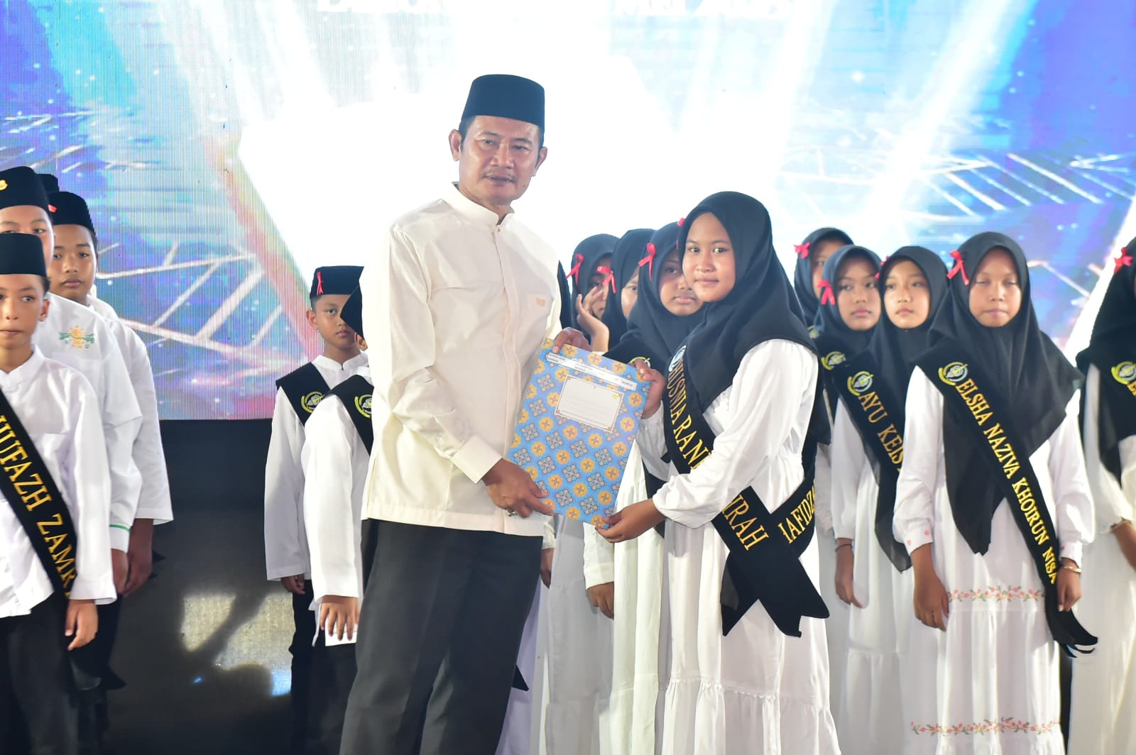 Bupati Yes menyerahkan sertifikat yang dikeluarkan LPTQ Lamongan kepada Hafidz hafidzah yang berhasil lolos seleksi hafalan juz.