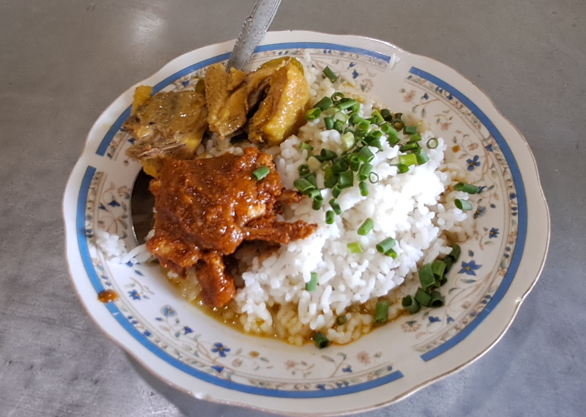 LANGGANAN PETAMBAK - GOWESER: Towiyah dan nasi kare yang dijualnya. Di warung ini juga bisa memesan kare campur bali. (GAMAL A/RDR.LMG)