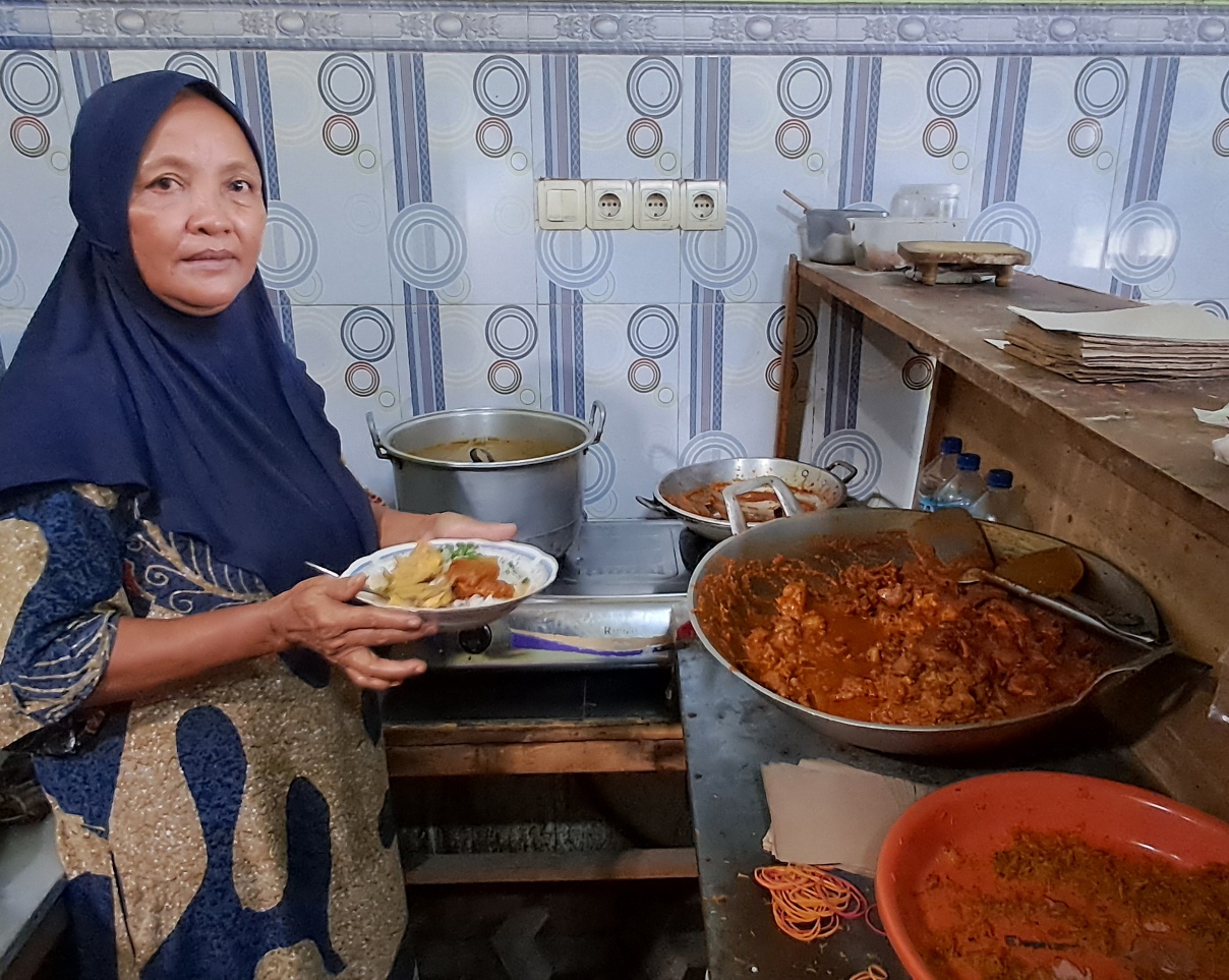 LANGGANAN PETAMBAK - GOWESER: Towiyah dan nasi kare yang dijualnya. Di warung ini juga bisa memesan kare campur bali. (GAMAL A/RDR.LMG)