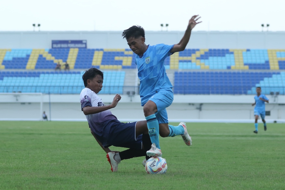 Pemain Persela Academy U-15, berusaha melewati kawalan pemain PSHW U-15 dalam partai final yang digelar di Stadion Surajaya Lamongan, Minggu (8/6) sore.