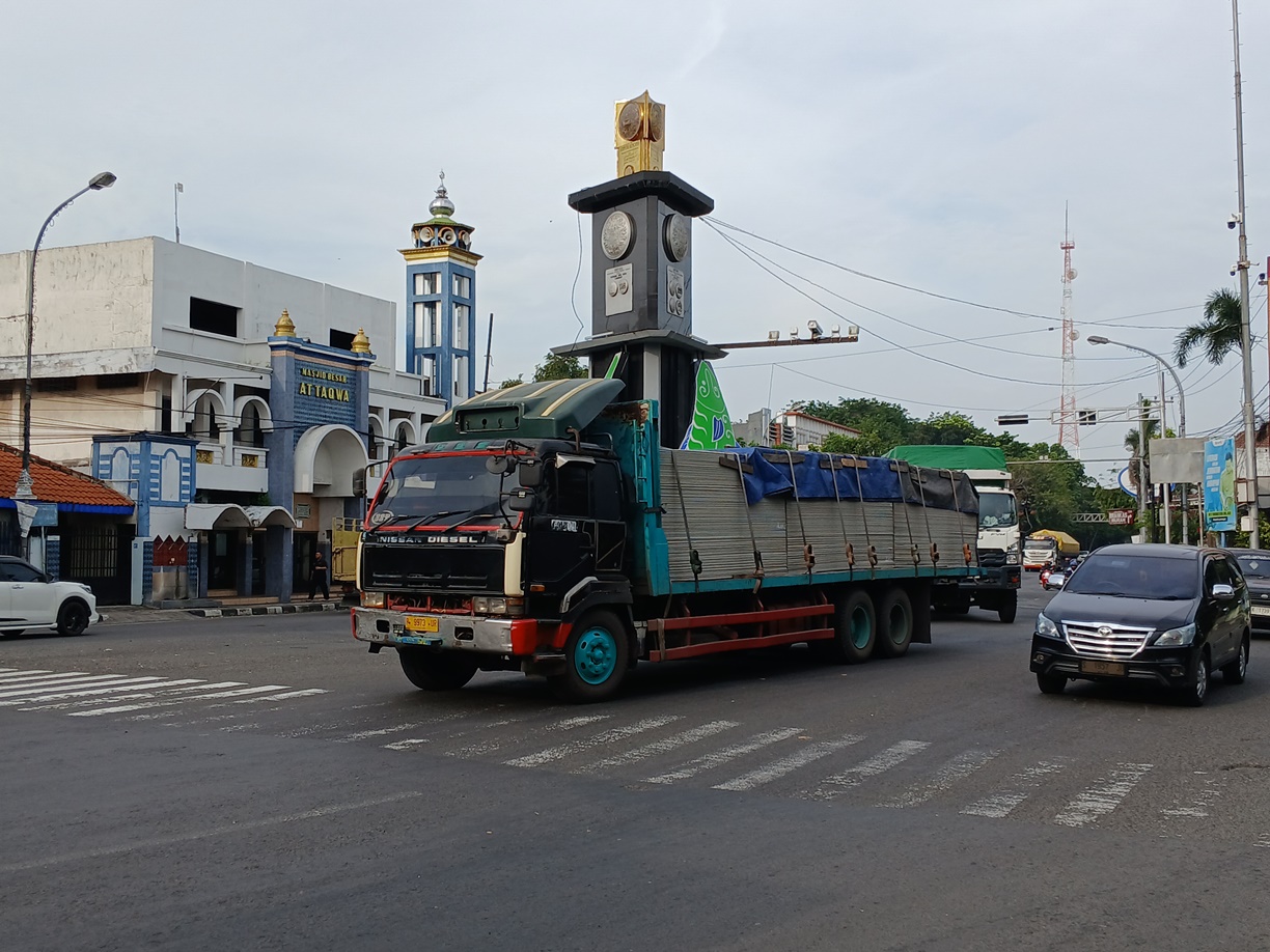 MELINTAS DI TUGU ADIPURA: Truk yang menuju arah Babat. Rencana penindakan truk yang melebihi muatan mulai bulan depan membuat sebagian kendaraan jenis itu melakukan pengujian. (ANJAR DWI PRADIPTA/RDR.