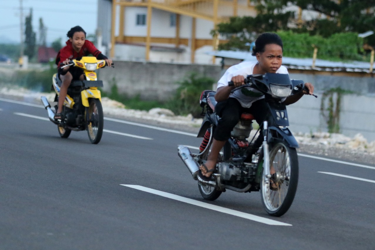 GAS &ndash; GASAN DI JALAN MULUS: Dua remaja mengendarai dua motor tanpa spion dan tidak berhelm. JLU menjadi tempat favorit remaja untuk tancap gas motor. (ANJAR DWI PRADIPTA/RDR.LMG)