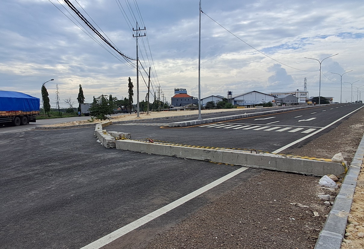 TUNGGU ADA TRAFFIC LIGHT DULU: Jalan mulus di kawasan JLU yang belum diresmikan diberi pembatas. (GAMAL A/RDR.LMG)