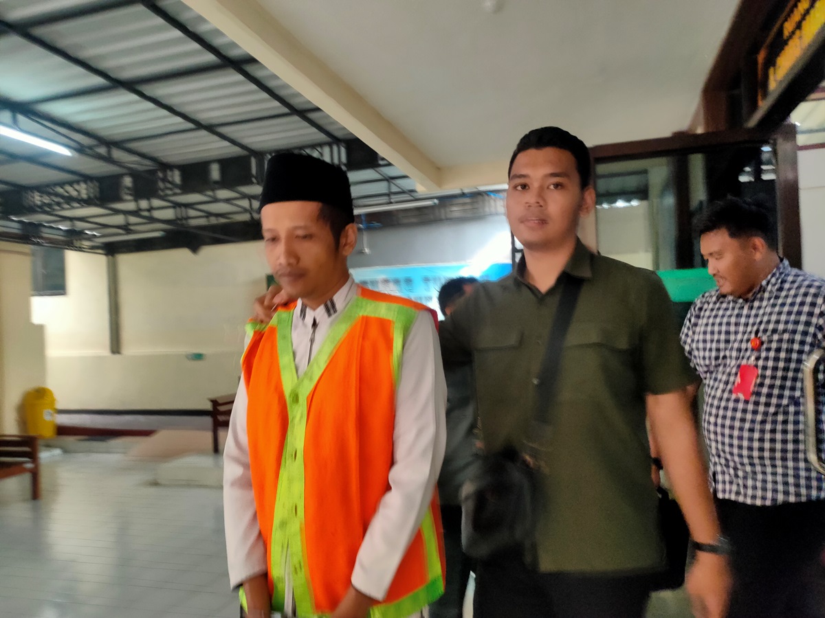 DITUNTUT DELAPAN TAHUN: Husnul Hikam didampingi petugas saat di Pengadilan Negeri Lamongan. Dia tersandung kasus karena menjadi perantara jual beli SS. (IST/RDR.LMG)