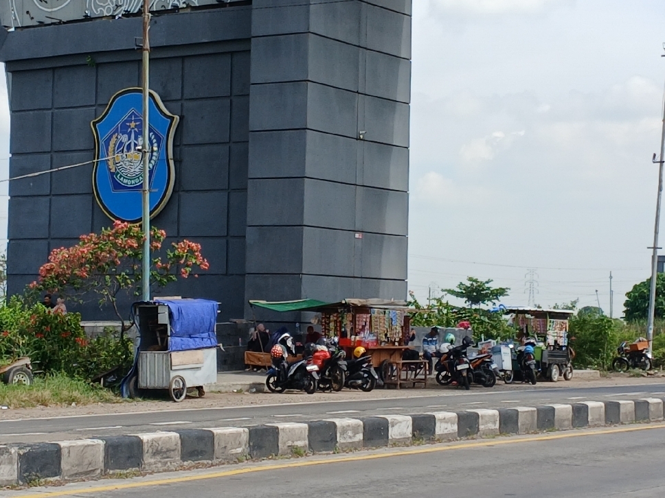 Tak hanya membawa rombong dagangan, PKL di sekitar tugu perbatasan Lamongan-Gresik juga terpantau membawa meja dan kursi, ini berpotensi berbahaya apalagi jalan ini termasuk jalur cepat kendaraan.