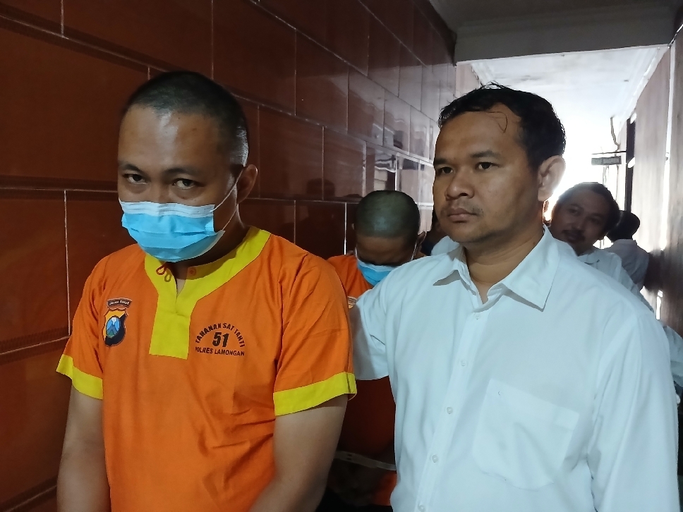 Dua tersangka kasus penyebaran konten asusila digiring petugas Polres Lamongan usai ditangkap dari aktivitas di grup online sesama jenis.