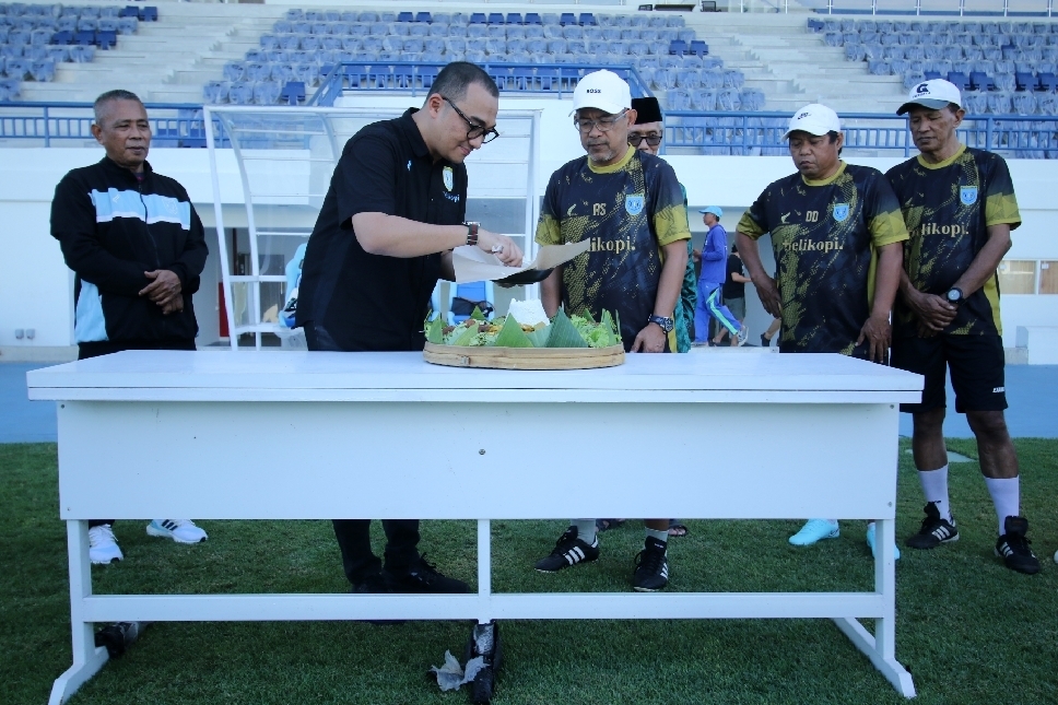 Proses pemotongan tumpeng oleh Asisten Manajer Persela, Rahadian Delfani, sebagai simbolis rasa ikhtiar tim kepada yang maha kuasa.