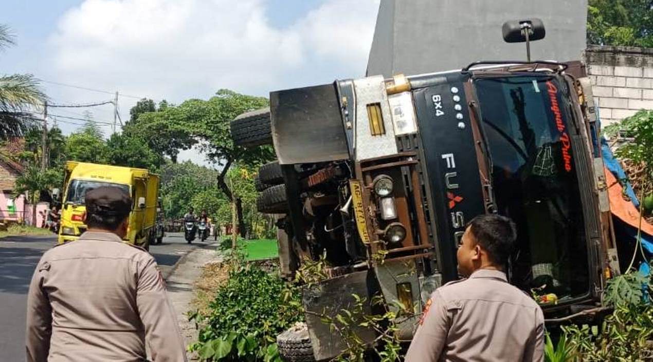 DI PINGGIR JALAN: Truk bermuatan bibit tebu terguling di tanjakan Girik, jalan  raya Babat - Ngimbang kemarin (2/7) pagi. (IST/RDR.LMG)