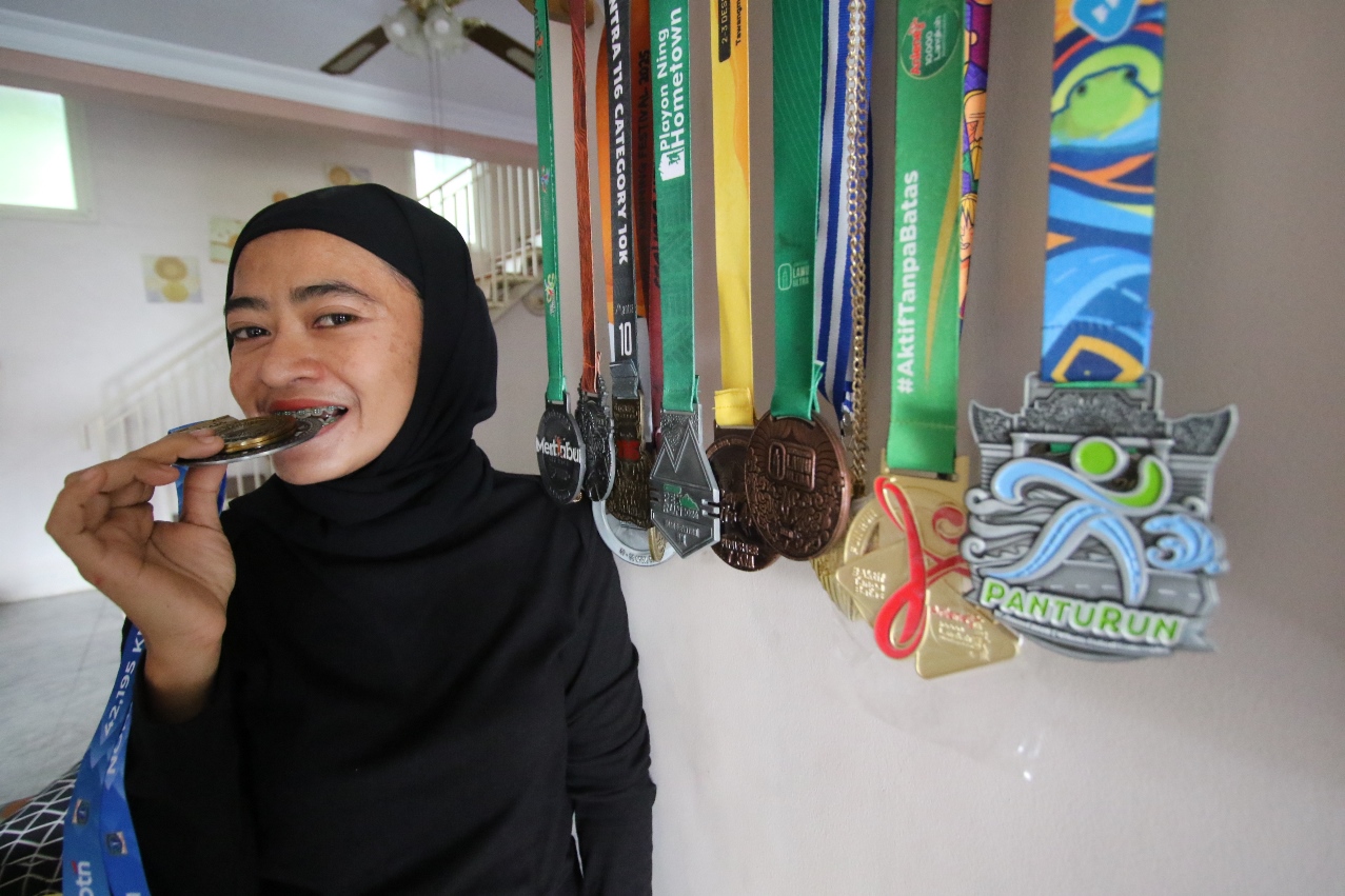 BUKTI IKUTI BANYAK EVENT: Efi Neo Wati menunjukkan deretan medali dari berbagai event yang diperolehnya dari berlari. (ANJAR DWI PRADIPTA/RDR.LMG)