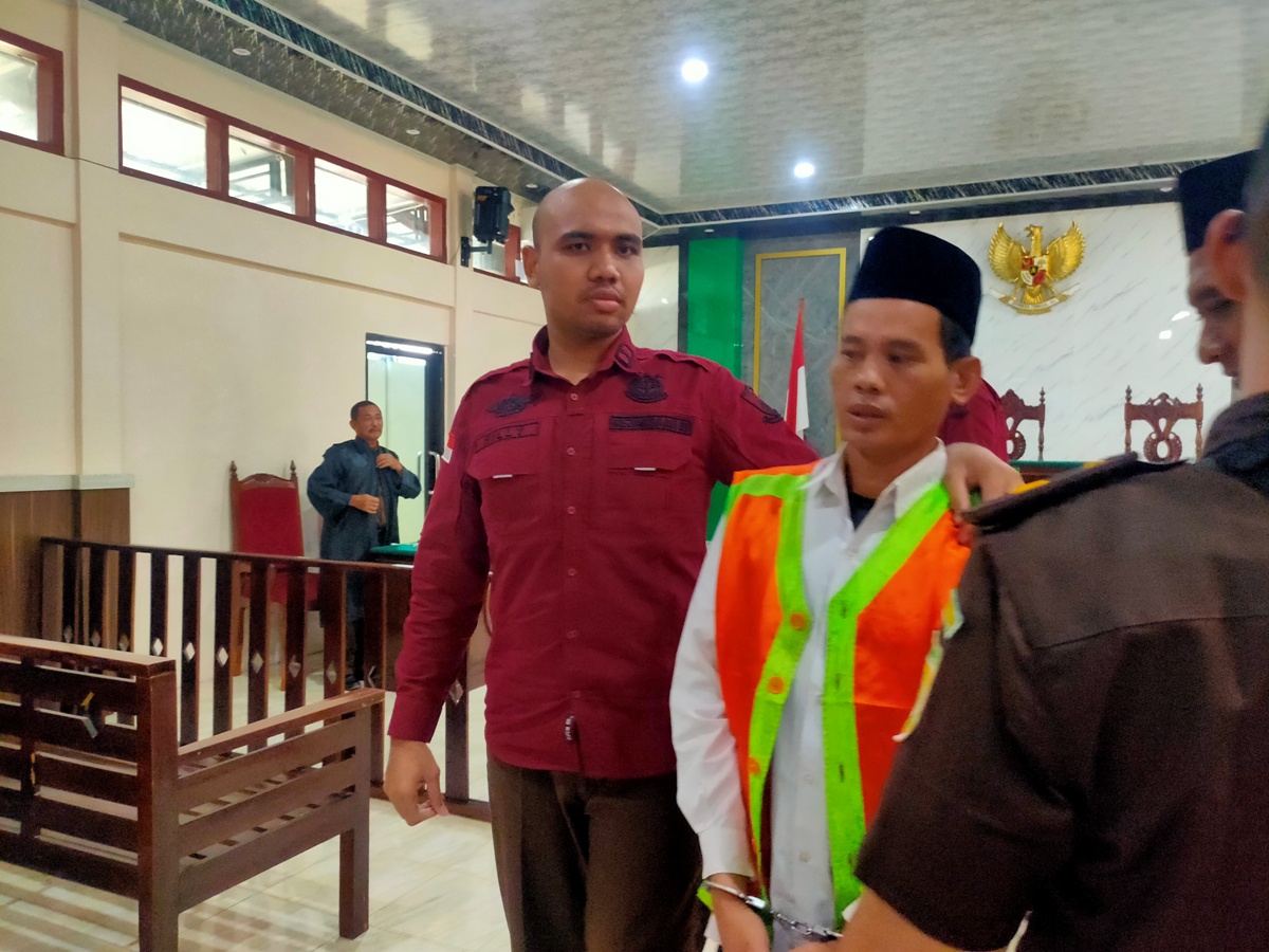 DIVONIS SEPULUH BULAN: Abdul Gofur dikawal petugas setelah menjalani persidangan di PN Lamongan. (IST/RDR.LMG)