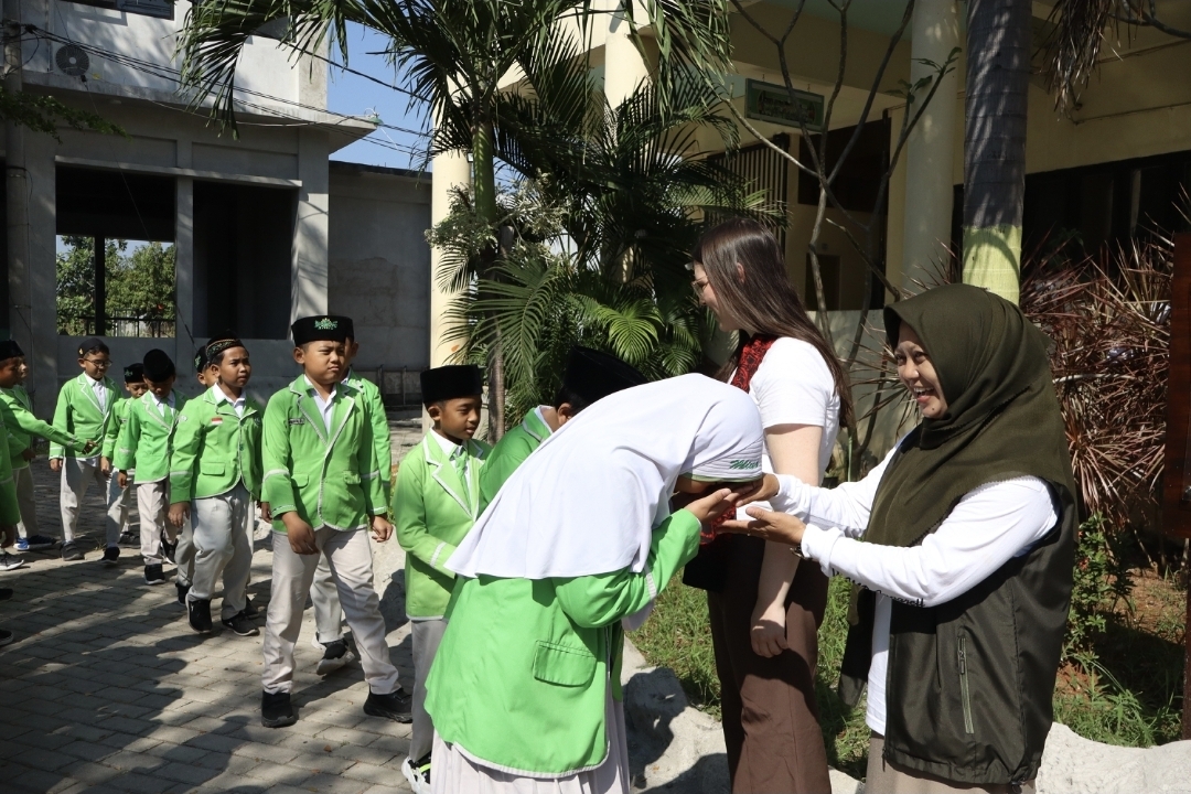 Kepala MI Unggulan Sabilillah Lamongan, Ustadzah Uswatun Hasanah, MA bersama Ms. Joanie Martineau dari Universite de Sherbrooke, Canada bersalaman dengan siswa-siswi.