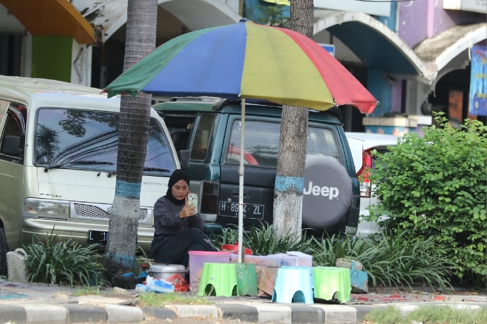 Penjual nasi boran di salah satu jalan wilayah Lamongan, berswafoto sembari menunggu pembeli dagangannya