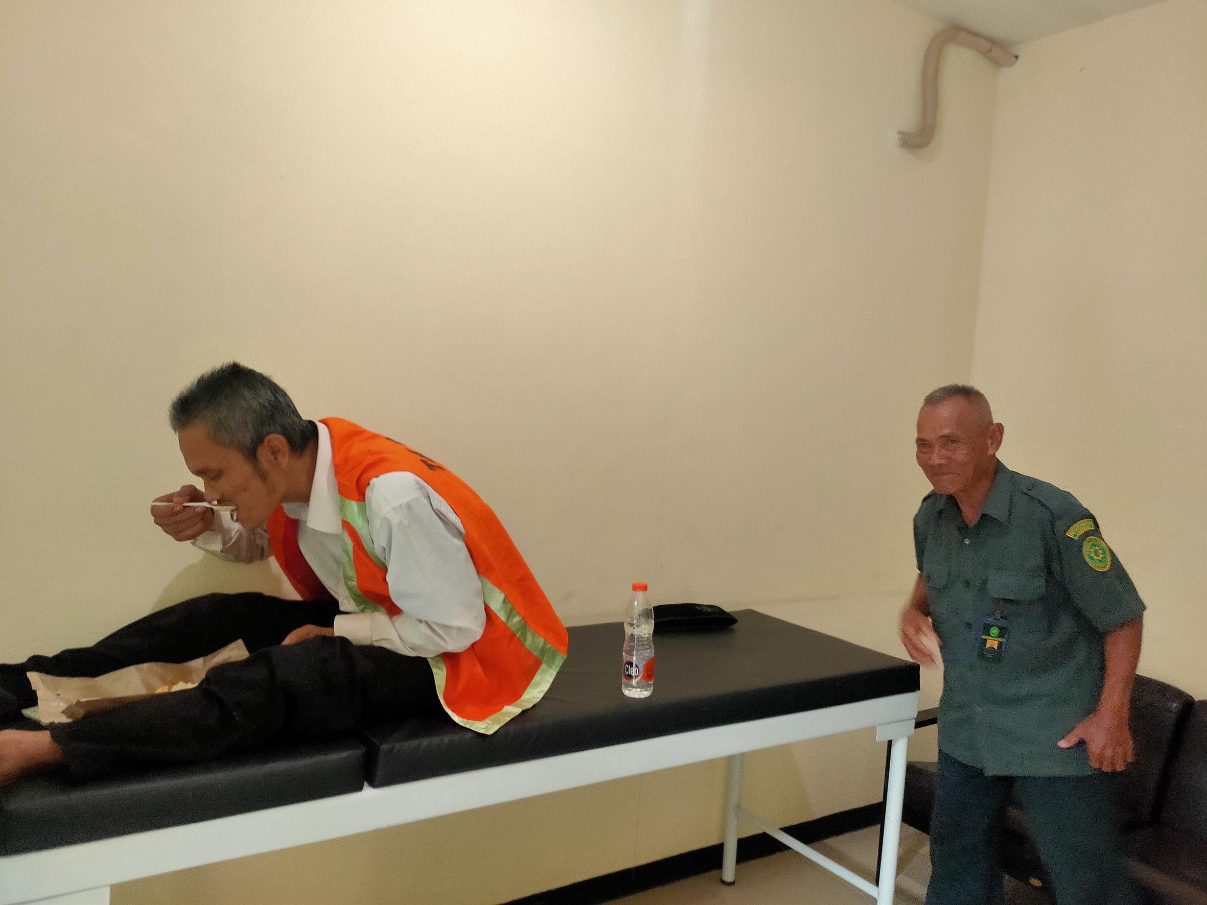 PULIHKAN KONDISI: Mochamat Budiman diberi makan setelah pingsan akibat mendengarkan putusan majelis yang menghukumnya dengan tujuh bulan penjara. (AHMAD ASIP ALAFI/RDR.LMG)