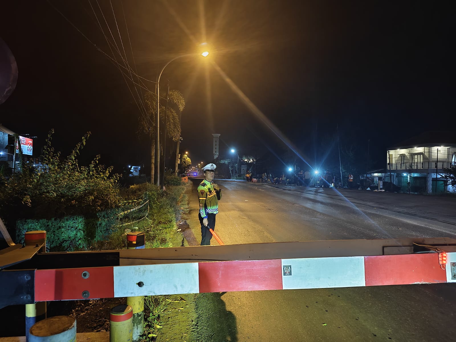 Petugas Satlantas Polres Lamongan saat mengatur arus lalin di perlintasan KA jalan nasional saat dilakukan perbaikan.&nbsp;