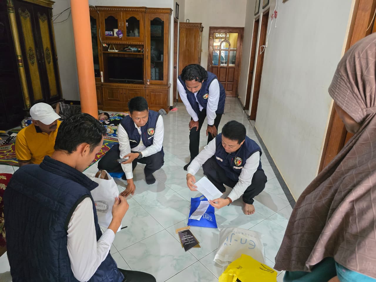 Petugas saat menggeledah rumah tersangka kasus arisan bodong di Desa Sugihan, Kecamatan Solokuro.