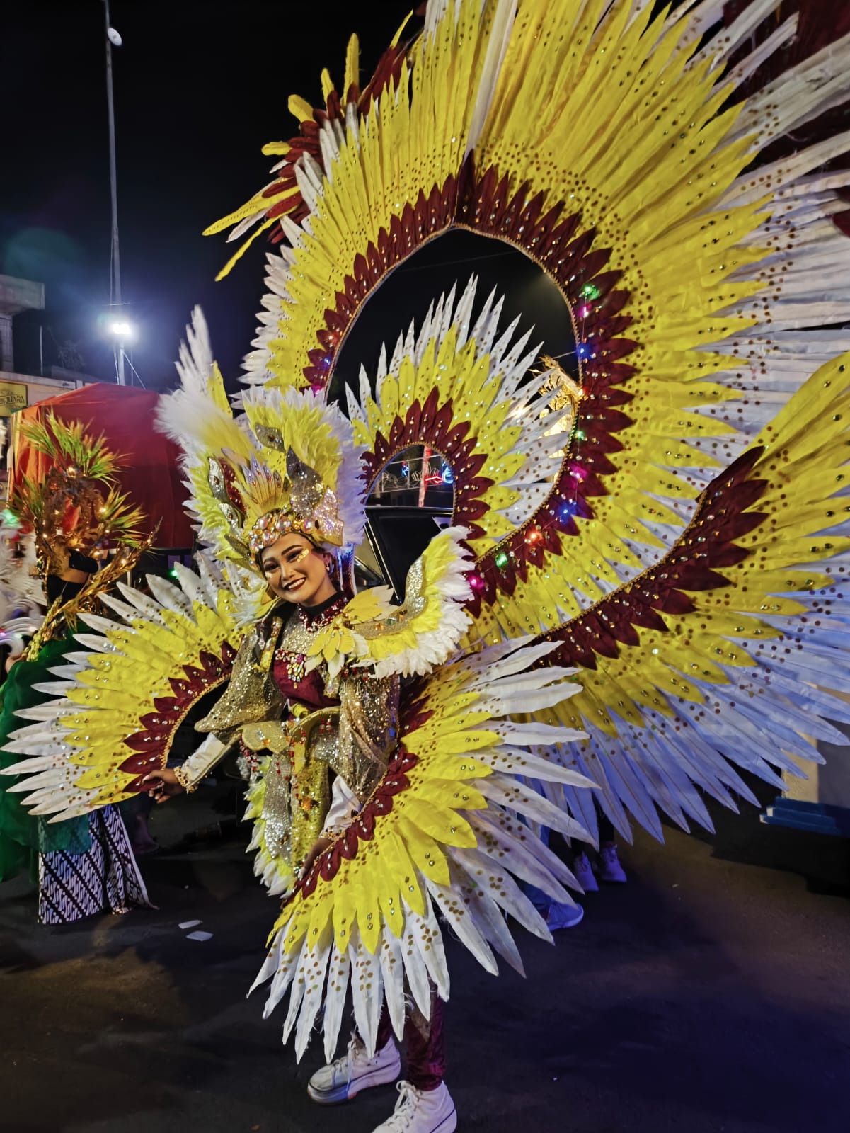 ANGGUN: Salah satu peserta dari SMAN 2 Lamongan tampil anggun dengan kostum warna-warni berbentuk sayap burung dalam gelaran Lamongan Night Carnival 2025.