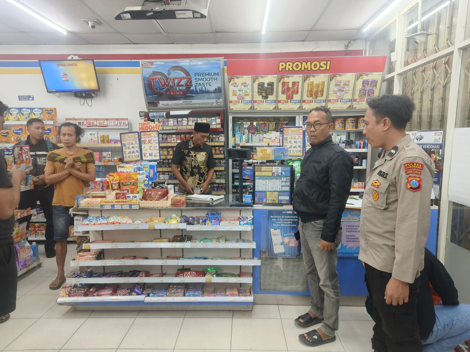 Petugas kepolisian melakukan penyelidikan di minimarket yang menjadi sasaran perampok bersenpi dan bersajam.&nbsp;