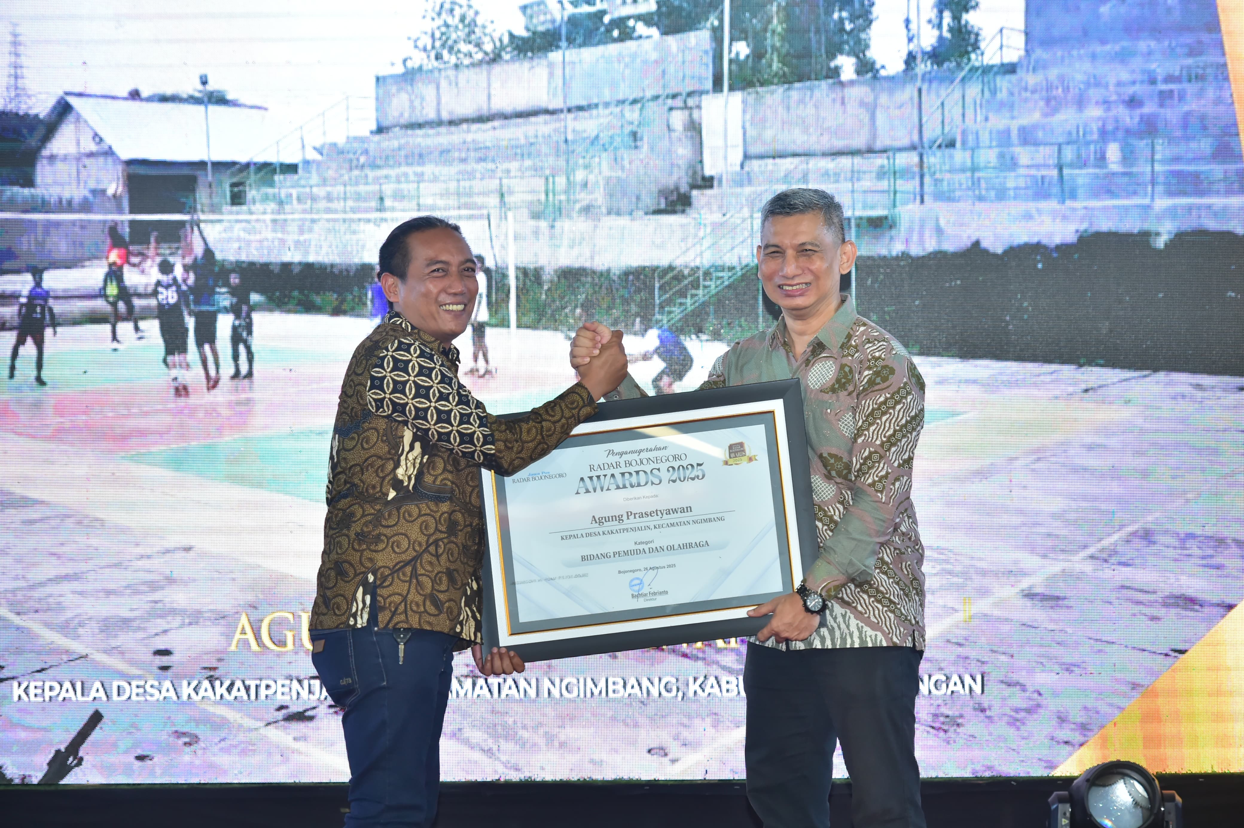 BERPRESTASI: Direktur Jawa Pos Radar Bojonegoro, Bachtiar Febrianto menyerahkan penghargaan kepada Kades Kakatpenjalin, Kecamatan Ngimbang, Agung Prasetyawan.