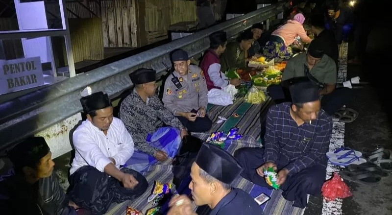 KIRIM DOA: Warga bersama petugas Polsek Pacet menggelar tahlil dan doa bersama di lokasi penemuan mayat korban mutilasi di jurang tepi jalur Pacet-Cangar, Senin (15/9) malam. (martda/jprm)