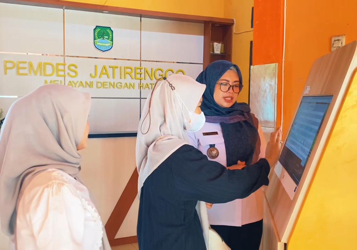 CARA MASUK JALANTOL: Try Deasy Kusumaning Ayu S.psi memberikan pelayanan kepada warga yang datang ke Balai Desa Jatirenggo, Kecamatan Glagah dengan memanfaatkan aplikasi Jalantol.