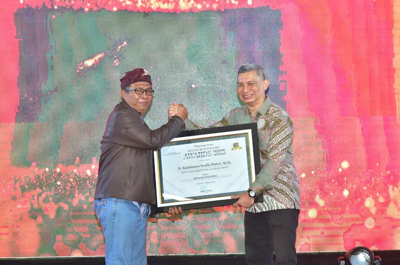 BUAH KERJA KERAS: Kades Deket Wetan, Kecamatan Deket, Ir. Kusbianto Susilo Putro, M.Si. menerima penghargaan Radar Bojonegoro Awards 2025 dari Direktur Jawa Pos Radar Bojonegoro, Bachtiar Febrianto.