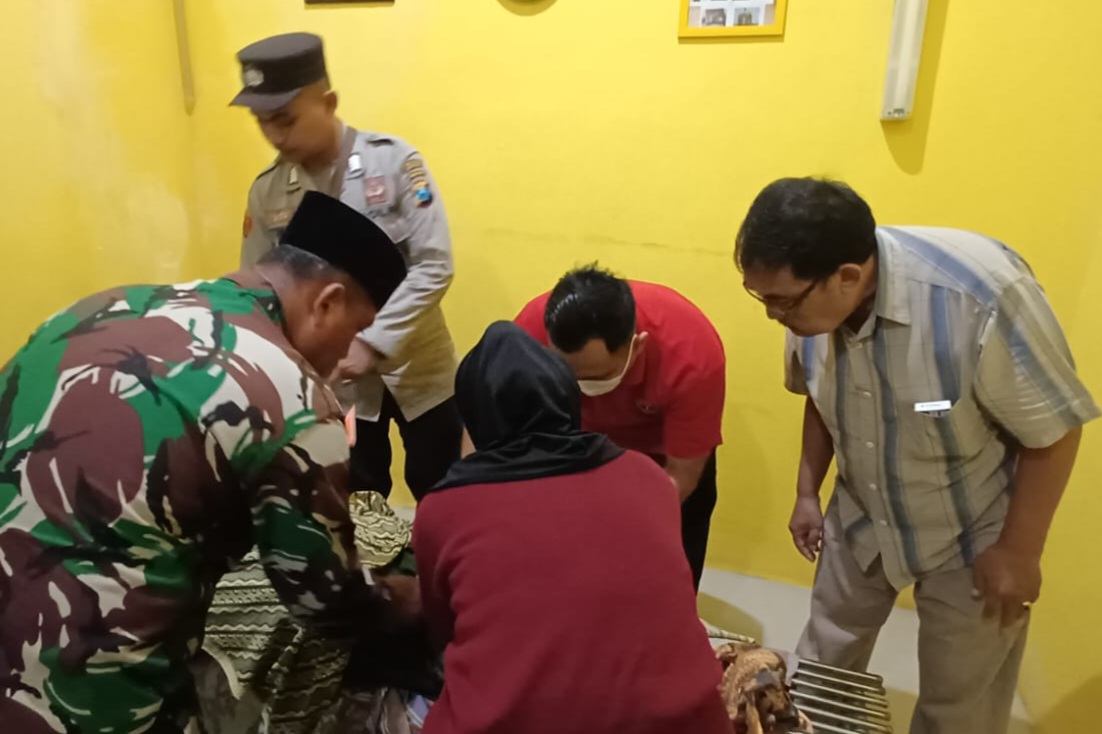 Petugas Dibantu oleh warga memerikasa kondisi Lansia yang ditemukan tewas di bantaran sungai Desa Putatkumpul.