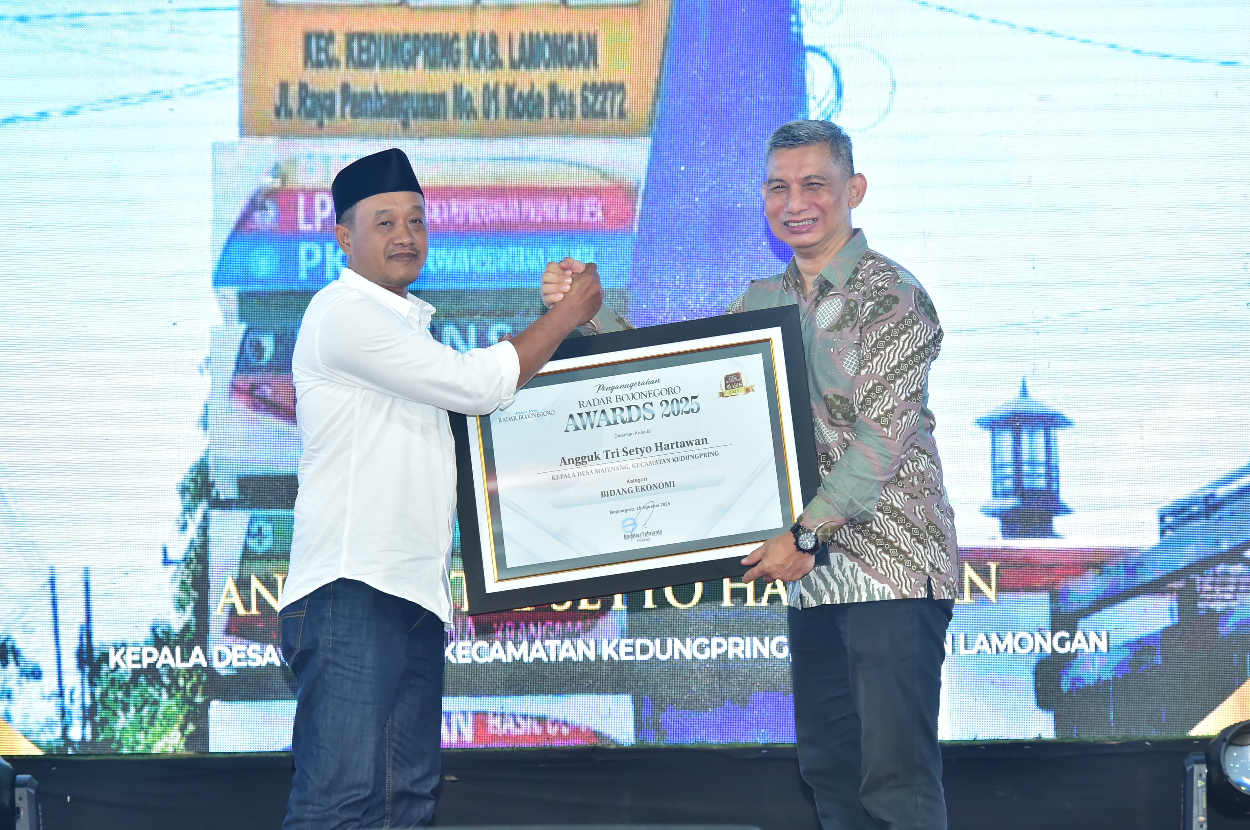 Kades Majenang, Angguk Tri Setyo Hartawan menerima penghargaan Radar Bojonegoro Awards 2025 Bidang Ekonomi yang diserahkan Direktur Jawa Pos Radar Bojonegoro, Bachtiar Febrianto