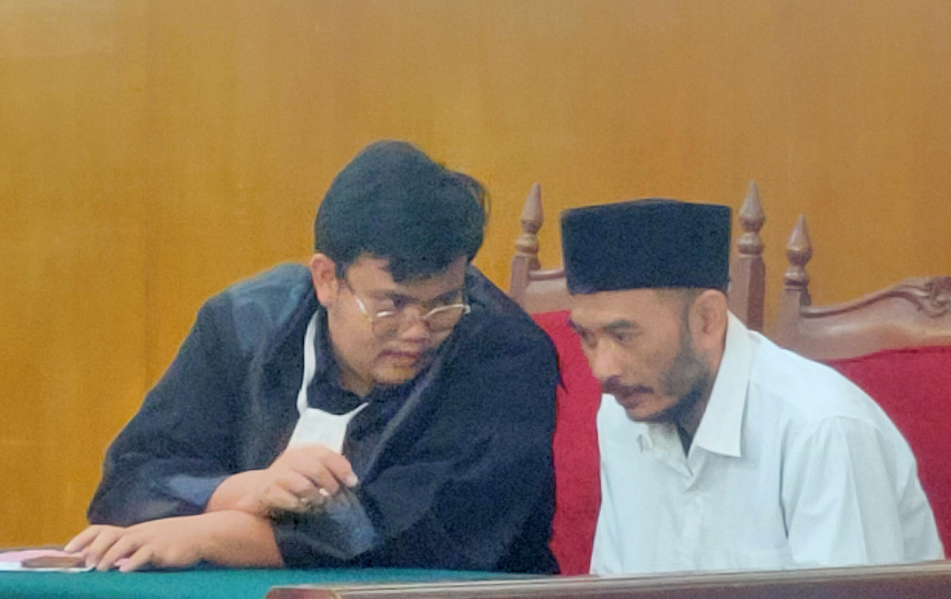 ANCAMAN MAKSIMAL 20 TAHUN: Heri Darwanto bersama penasihat hukumnya di Pengadilan Negeri Lamongan. (IST/RDR.LMG)